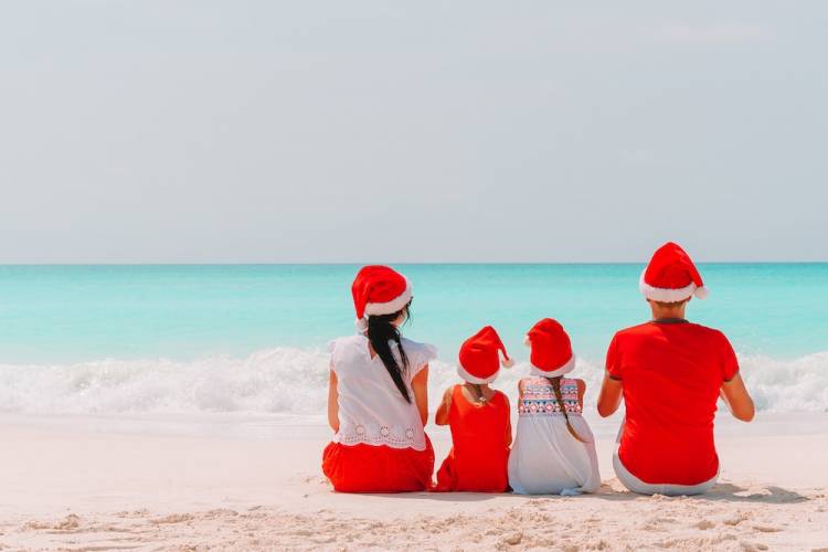 family on the beach with Christmas hats