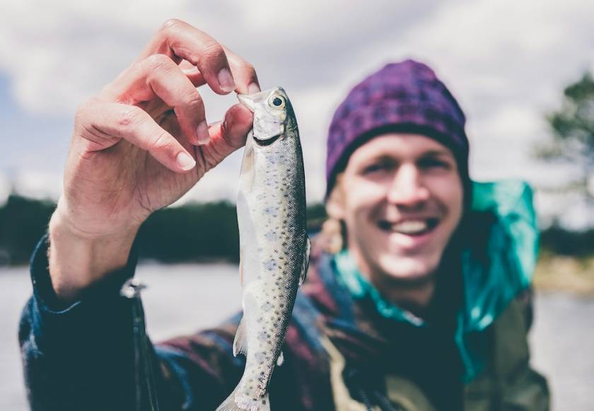 man holding fish on boat