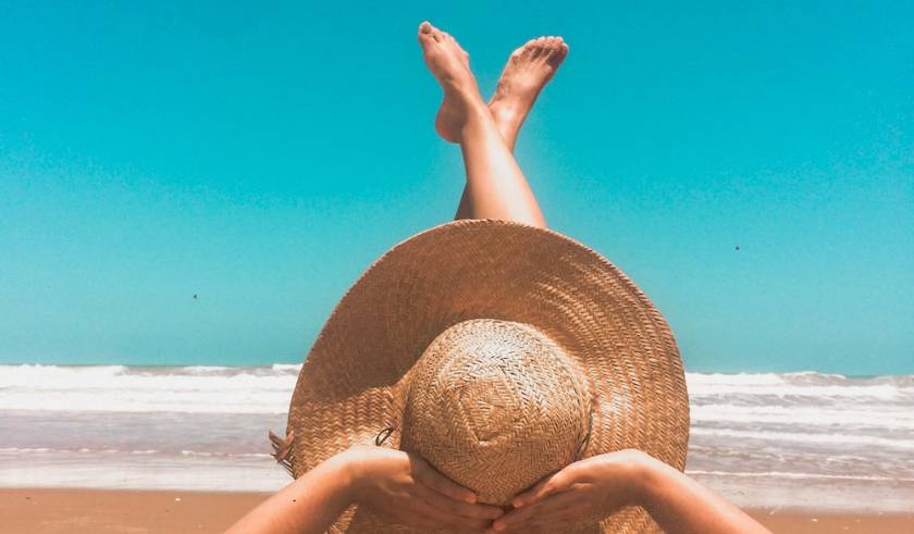 woman laying on beach in sand